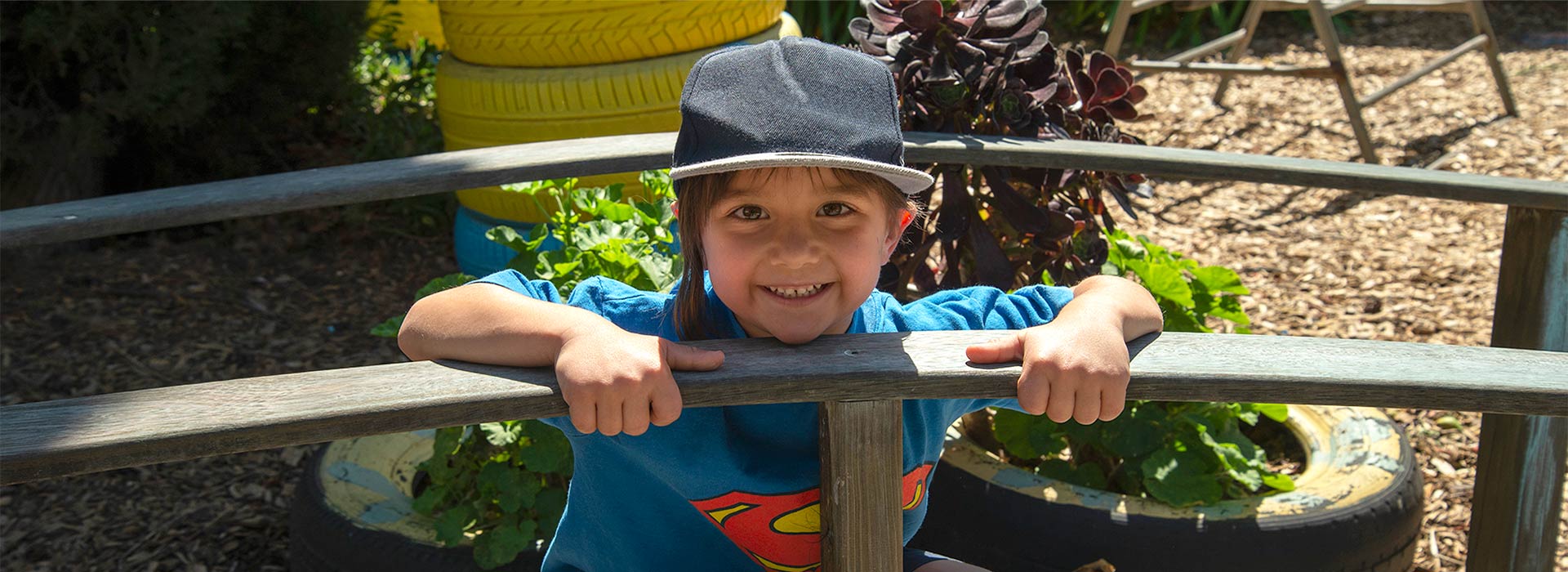 Happy 4 year old kindy student playing outside in the garden at Glenroy West Kindergarten